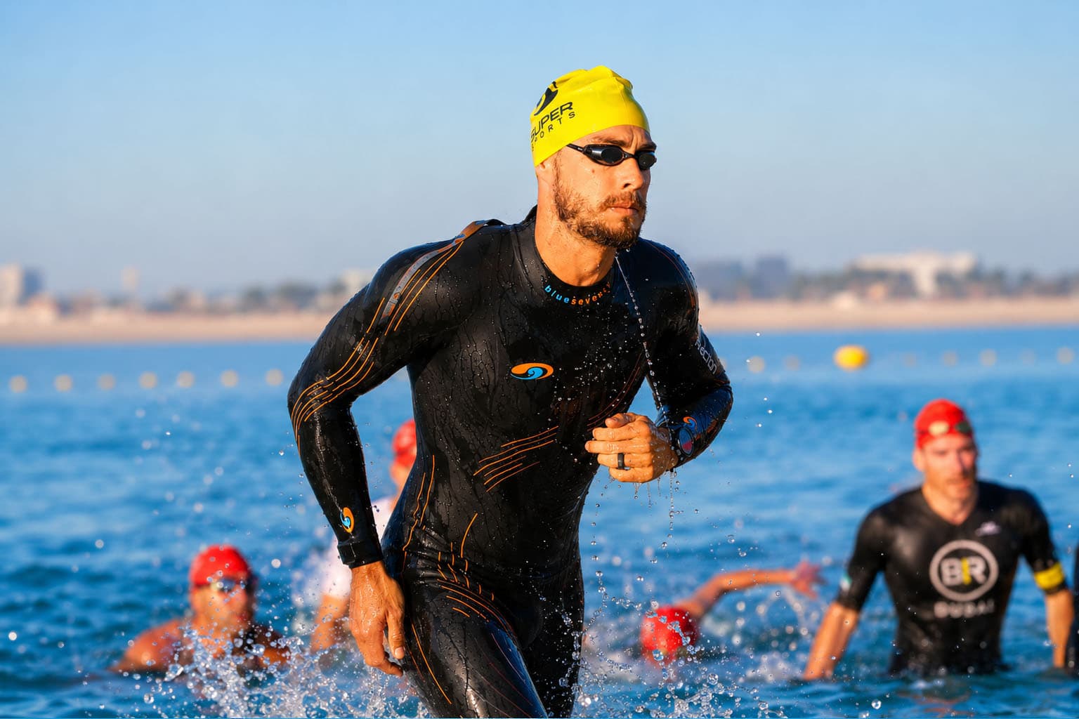 Open water swimmer in a wetsuit exiting the water after a race