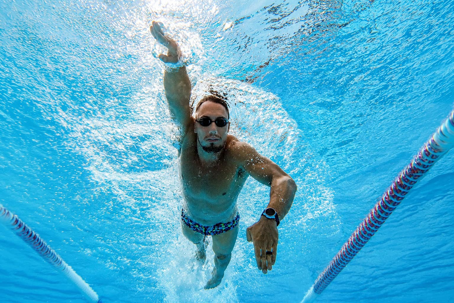 Swimmer training freestyle underwater in a pool lane